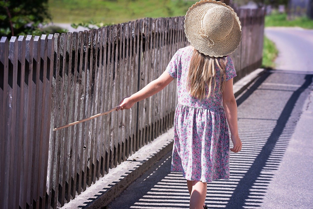 clôture en brande avec fille enfant qui marche le long